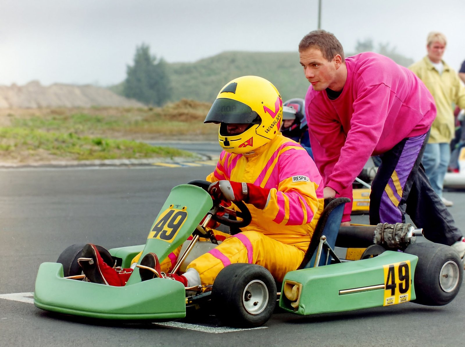 Start-Anschub bei einem Kartrennen. Ein Mann schiebt das Kart mit dem Rennfahrer an.