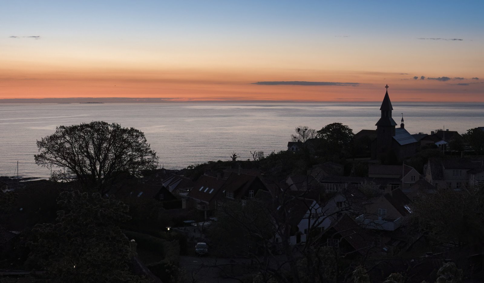 Blick über Gudhjem zur blauen Stunde mit Morgenrot über dem Meer