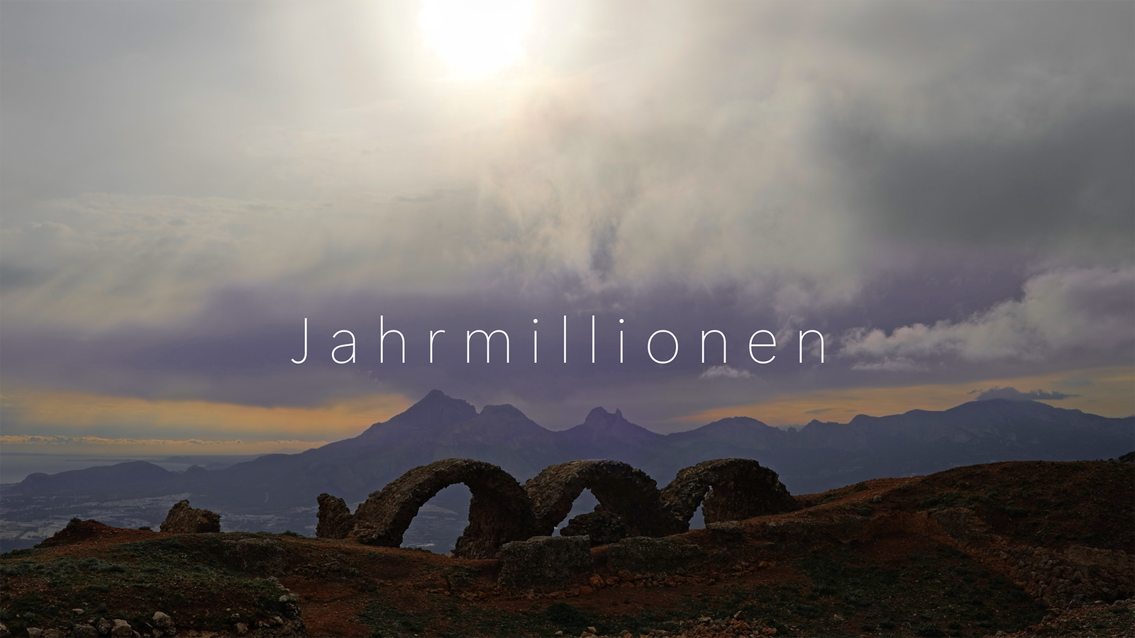 Titelbild mit Berglandschaft dunkle Wolken mit Sonne, Ruine eines Fort